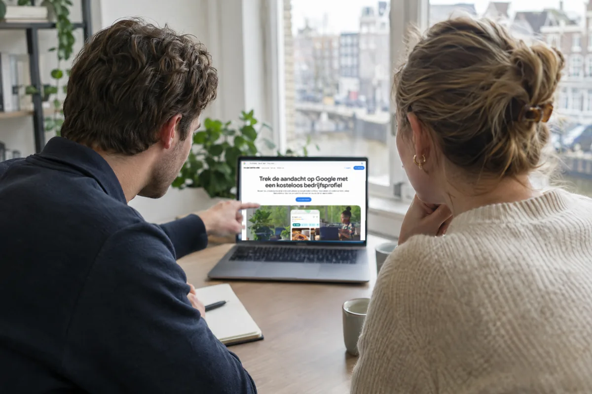Twee collega’s bekijken samen een bedrijfsprofiel op een laptop